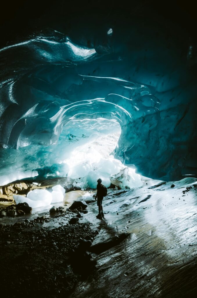 pexels-photo-2444444-2444444 Silhouetted figure explores the stunning interior of a glacial ice cave.